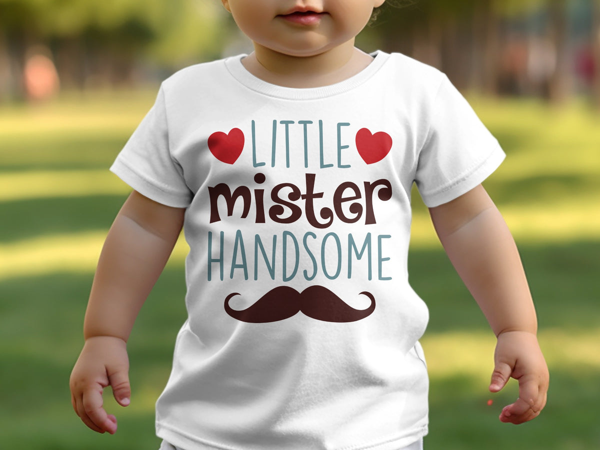 A baby wearing a white t-shirt printed with the text little mister handsome and a mustache.