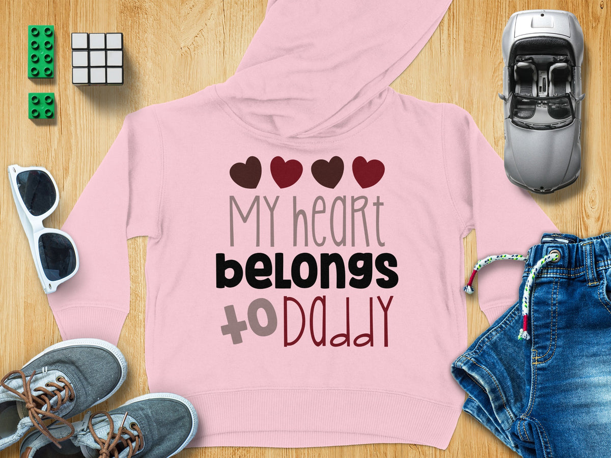 A pink children's hoodie with the text My heart belongs to daddy and red hearts.