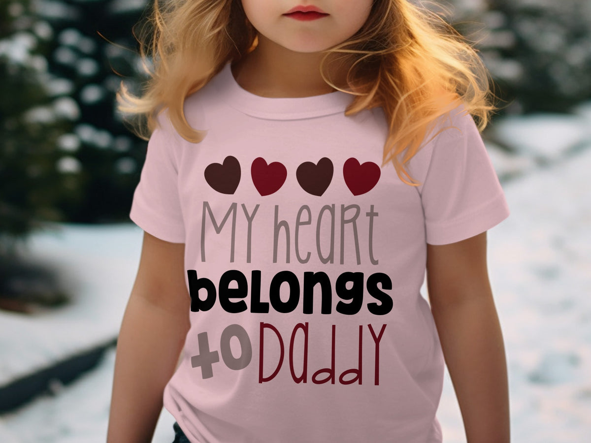 A child wears a light pink t-shirt with the text My heart belongs to Daddy.