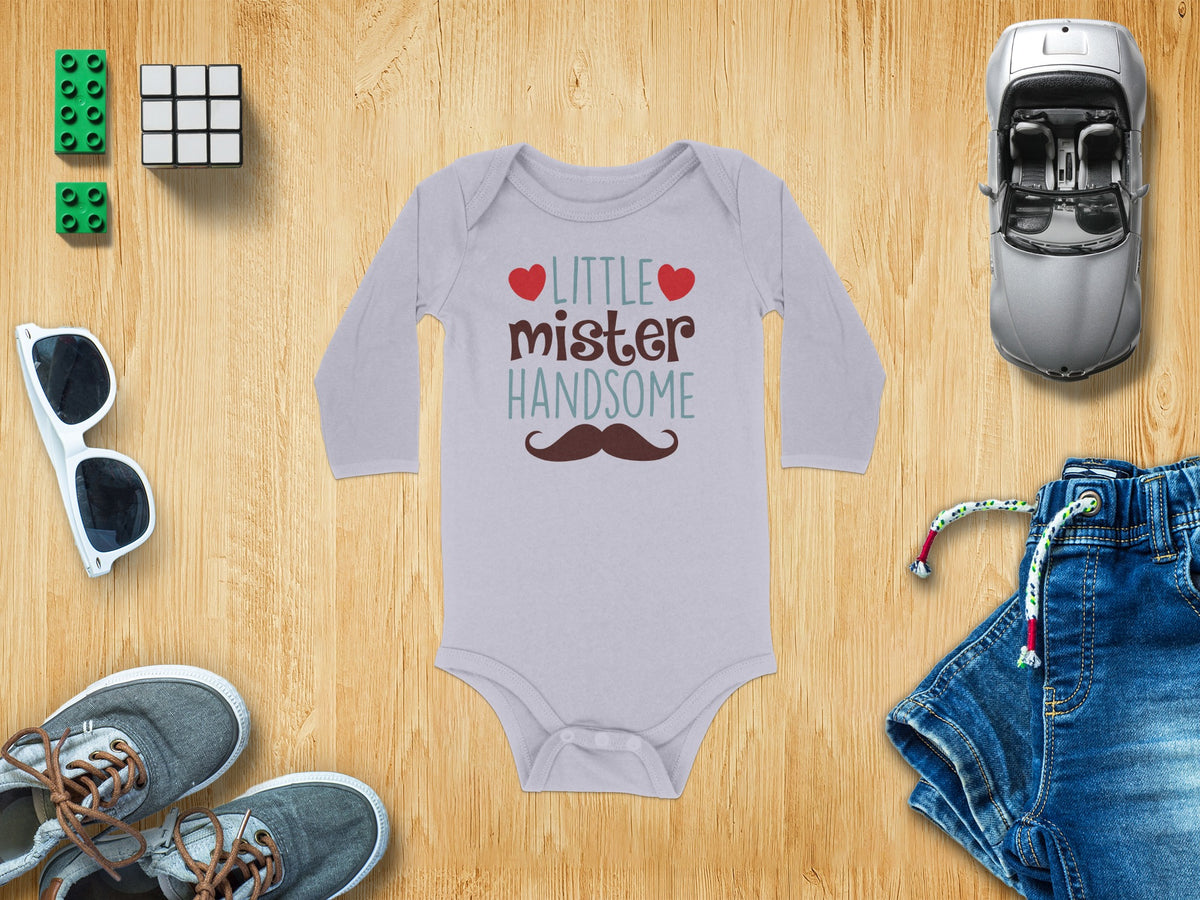 Light grey long-sleeved baby onesie printed with the text Little mister HANDSOME, red hearts, and a brown mustache.