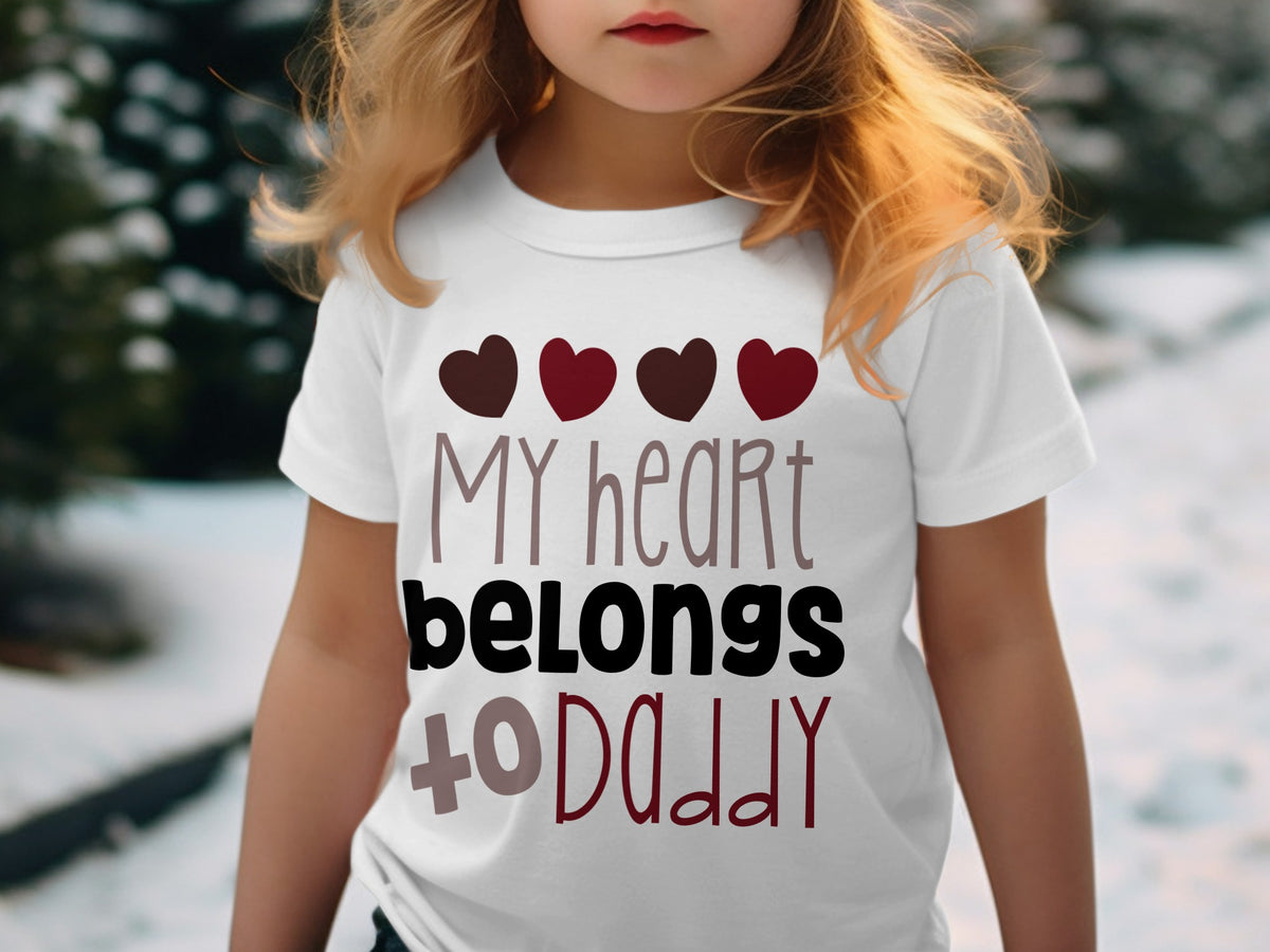 A young child wearing a white t-shirt printed with four hearts and the text My heart belongs to Daddy.