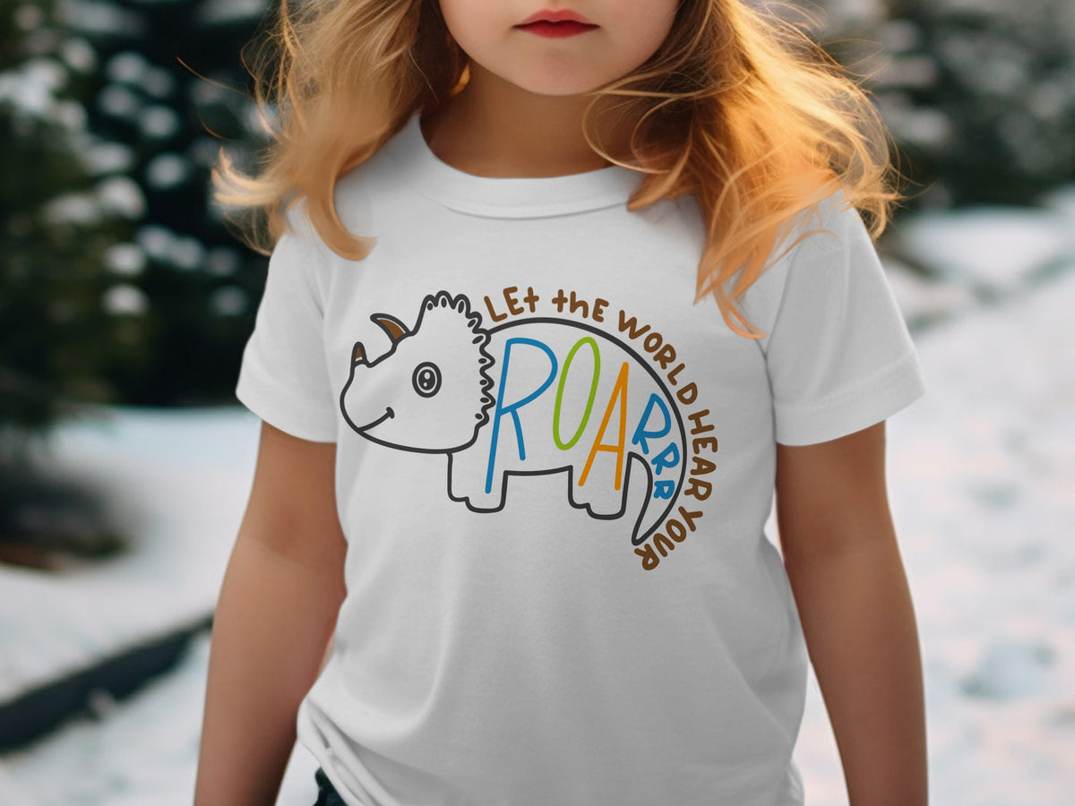 A child wearing a white t-shirt featuring a cartoon triceratops and text reading "LET THE WORLD HEAR YOUR ROAR".