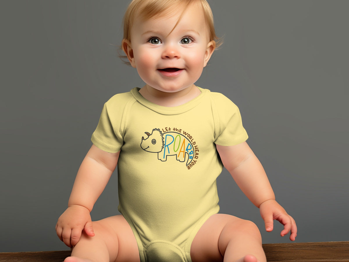 A smiling baby with blonde hair sits wearing a yellow onesie featuring a dinosaur graphic and text.