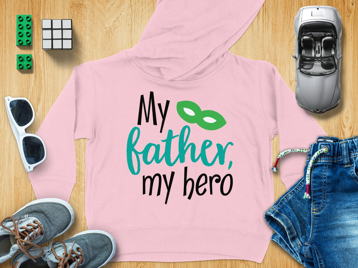 A pink children's hoodie with the text My father, my hero surrounding a green mask.
