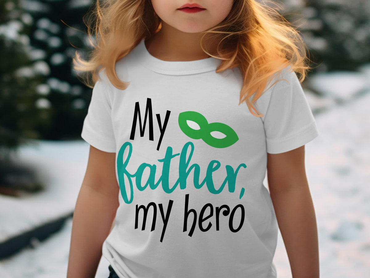A young child wearing a white t-shirt printed with the black and teal text My father, my hero and a green superhero mask.