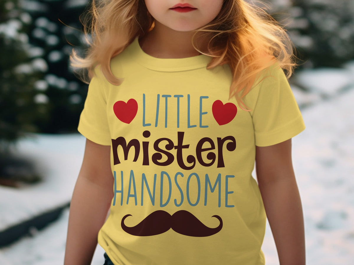 A child wearing a yellow t-shirt with the text LITTLE mister HANDSOME and a mustache graphic.