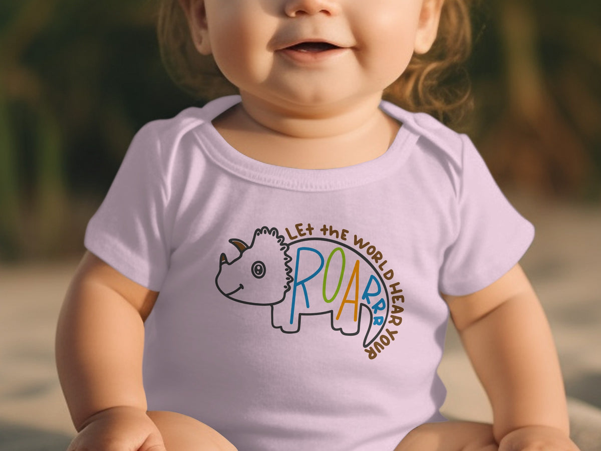 A smiling toddler wearing a light purple short-sleeve bodysuit featuring a triceratops outline and text.