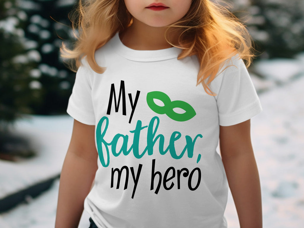 A young child wearing a white t-shirt printed with the text My father, my hero and a green mask.