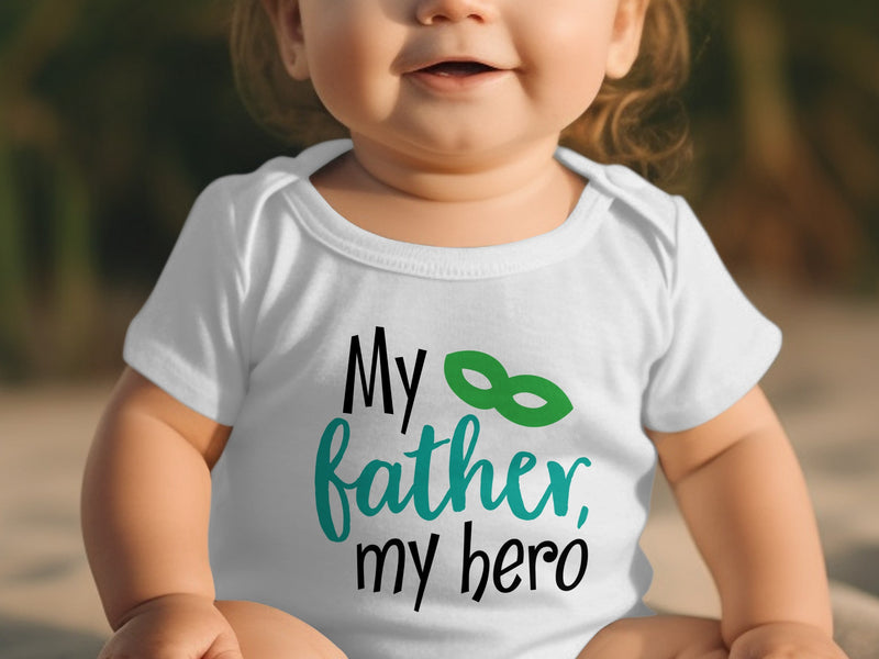 A baby wearing a white short-sleeve bodysuit with the black and teal text My father, my hero.